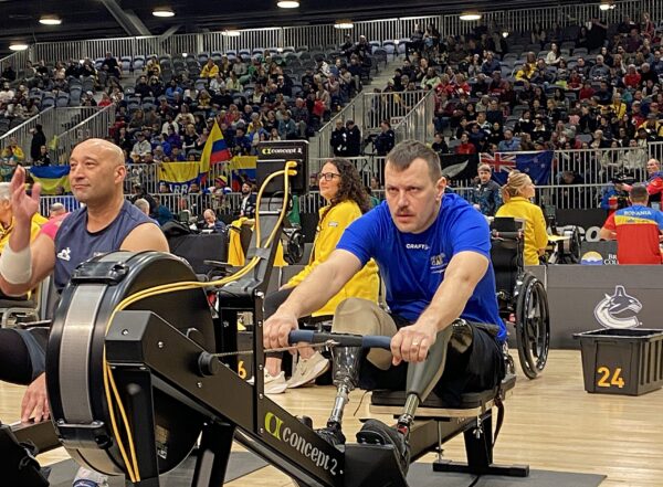 Ratastoolis paraatlet sõudetreeningul spordiareenil, publiku ees.