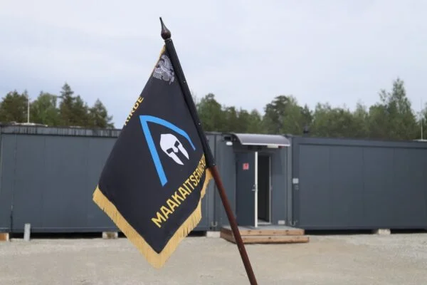 Sõjaväe veokid raketiheitjatega seisavad lennuväljal, taustal suur transpordilennuk ja tegevuses personal.