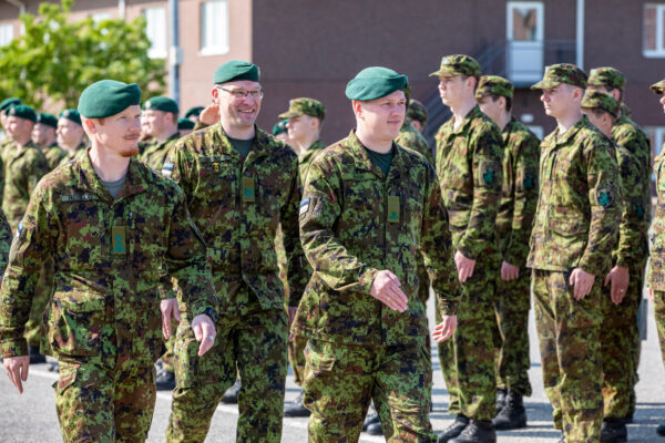 Eesti kaitseväelased rivistusel, ees sammuvad roheliste barettidega allohvitserid kamuflaaživormis, taustal seisab rivi sõdureid