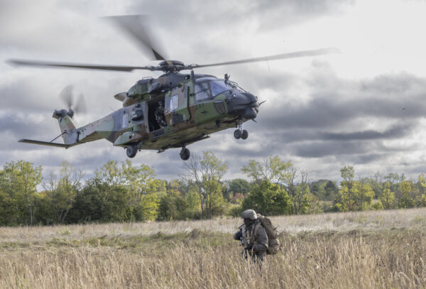Aasa kohal jõljuv helikopter ja selle all iikuv sõdur