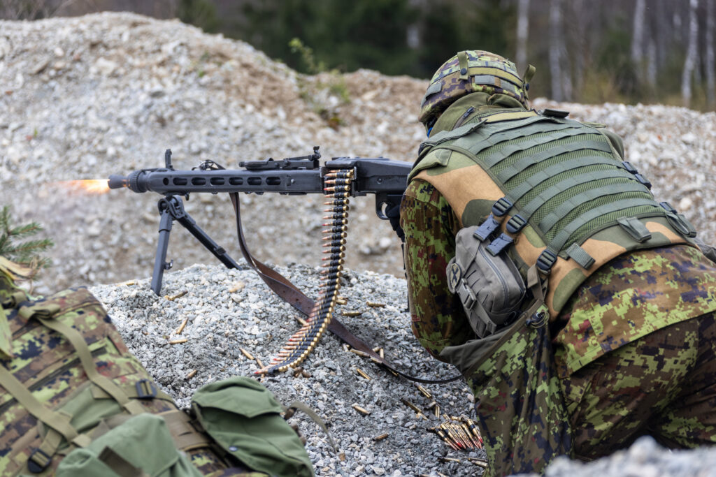 Mees kuulipilduja MG-3'ga positsioonil laskmas