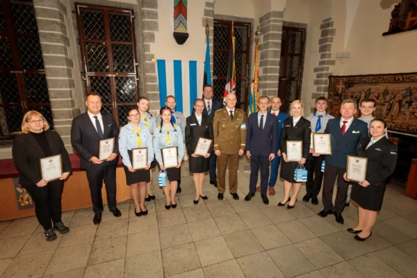 Naiskodukaitsjad, kaitseliitlased ja noored kotkad seisavad tallinna raekojas diplomid käes grupipildi