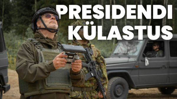 Kujundatud videpilt. President kaitseväe varustuses, kiiver peas, käes hoidmas droonipulti, pilk suunatud taevasse. Tema kõrval, paremal, seisab kaitseväelane, kes samuti vaatab taeva poole. Vasakul taga paistab METS JA kaitseväe määstur Mercedea Benz GD.